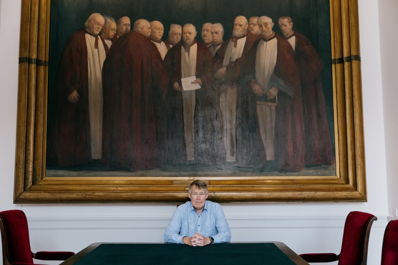 Højesteretspræsident Jens Peter Christensen foran et maleri af gamle højesteretsdommere. 